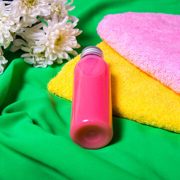 Spa set for body care, a bottle of gel for spa procedures lies on bath towels on a green background, copy space, flat lay, template