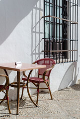 Reserved table on a bar in Osuna, Seville, Spain.  Whitewashed wall and steel lattice window.