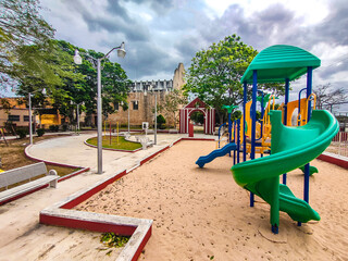 Children's playground in the town of Conkal with an old church in the background