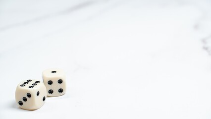 2 cream colored dice on marble top