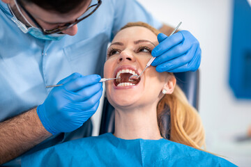 Dentist examining a patient's teeth in dentist office