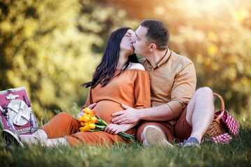 Portrait of a happy pregnant couple at picnic