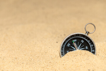 Fototapeta na wymiar Compass on the sand at the beach. Concept of travel