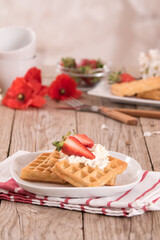 Waffles with strawberries and whipped cream.