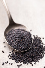 Bio natural black sesame seeds on mettal spoon.