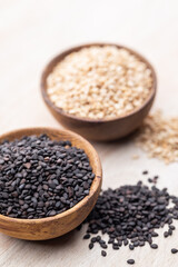 White sesame and black sesame seed on wooden bowl.