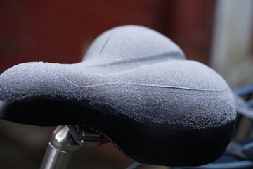 a bicycle saddle covered with ice