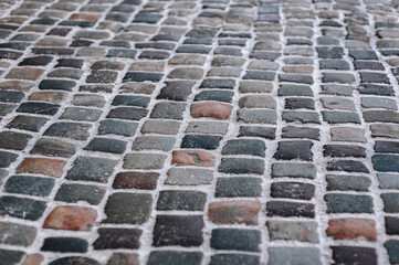 Fototapeta premium The gray paving stones close up. The texture of the old dark stone. Road surface. Vintage, grunge.