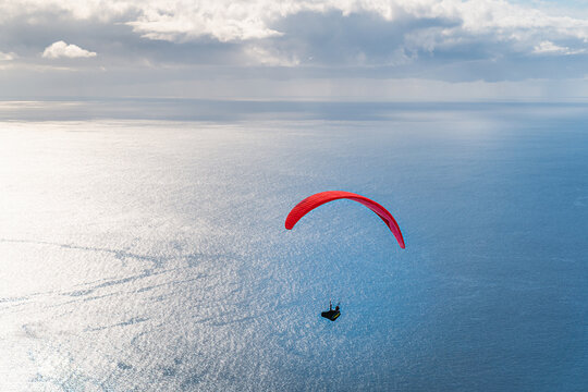 Paragleiter fliegt dem offenen Meer entgegen