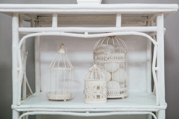 Fototapeta na wymiar White decorative bird cages stand on a shelf.
