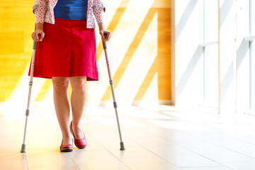woman practicing walking on crutches - 486767380