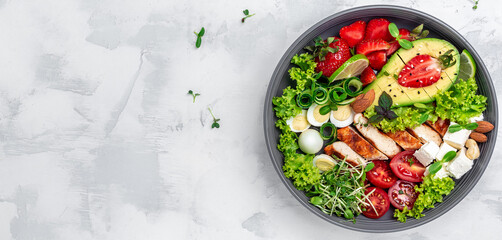 Ketogenic diet food, chicken fillet, quinoa, avocado, avocado, feta cheese, quail eggs, strawberries, nuts and lettuce. healthy meal concept, Long banner format. top view