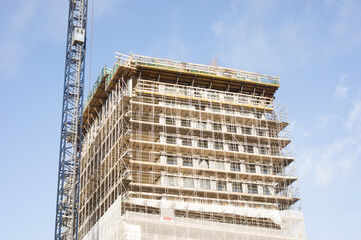 Large residential tower under construction with large blue crane n Nijmegen in the Netherlands