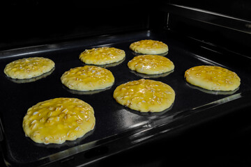 Process of cooking eight homemade crunchy oatmeal cookies on metal sheet in oven. Dessert, cookery,...