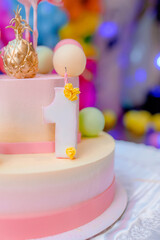 Beautiful cake with pink decor mastic for the birthday of a little girl. Candy bar. Baby birthday theme with flamingo. Festive background decoration with cake and balloons in studio.