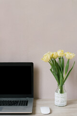 Technologies and concept of remote work. Front view of beautiful copywriter workplace with fresh flowers