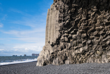 The famous Black Sand ocean Beach, mount Reynisfjall and Picturesque Basalt Columns, Vik, South Iceland. Dyrholaey Cape and rock formations in far. - Powered by Adobe
