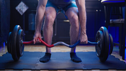Headless male person deadlift barbell at home in kitchen