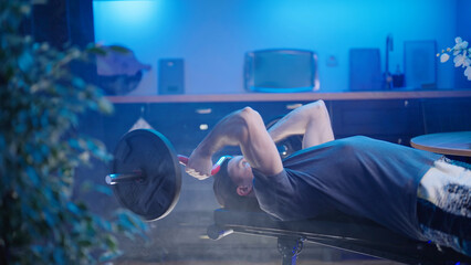 Male person skull crusher triceps exercise on bench at home in kitchen