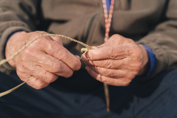 details of the hands of a craftsman making a rope