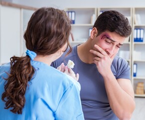 Obraz premium Young man visiting female traumatologist with black eye