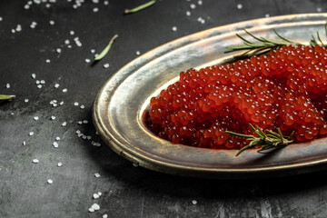 Red caviar in vintage plate on dark background. banner, menu, recipe. selective focus, place for text