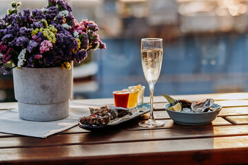 Fresh open oysters with a glass of chilled prosecco wine and set of shoot alcoholic cocktails served on table. Seafood delicios