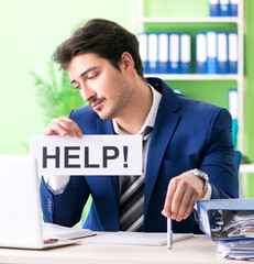 Businessman unhappy with excessive work sitting in the office