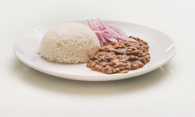 Lentiles portion served with rice and onion salad.