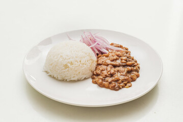 Lentiles portion served with rice and onion salad.