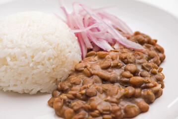 Lentiles portion served with rice and onion salad.
