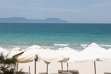 White beach umbrella on the beach against the blue sky and blue sea background on sunny day