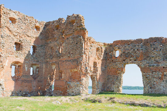 Ruines of the medieval Luzen castle, built by the Livonian knight order, in nowadays Ludza, Latgalia, Latvia. Red brick walls, blue sky, green grass