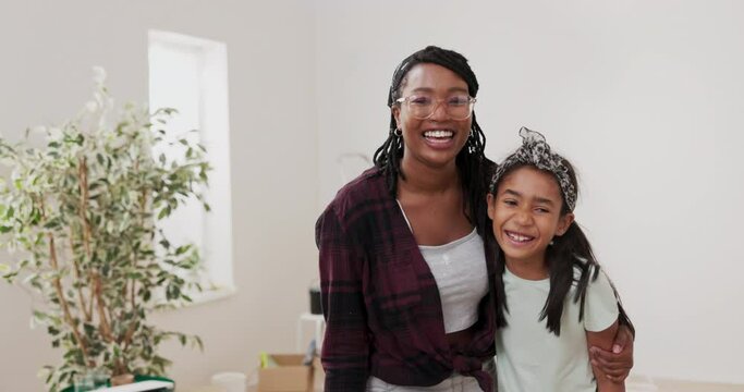 Young woman hugs and embraces her younger sister, daughter, together they look at the camera with smiles, laughing, resting after painting walls, renovating a room