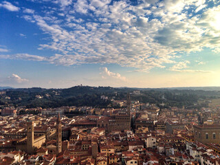 Firenze, Italy. Panoramic view of Florence from the top of Campanile close to Duomo. Tuscany hills on a horizon. Golden hour, cloudy sky.	