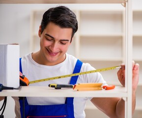 Worker man repairing assembling bookshelf