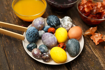 Beautiful Easter eggs with marbled stone effect, colored with natural dye turmeric, onion husk, hibiscus flower tea on dark wooden background
