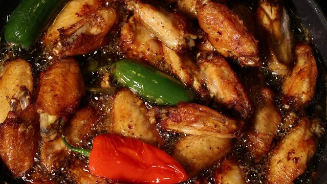 Chicken Wings Sizzle In Pan With Hot Oil. Top View Of Deep Fry Poultry At Home With Hot Bubbling Oil.