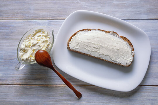 Balkan cuisine. Kaymak - local soft white cheese - on slice of bread . Rustic table, flat lay, copy space