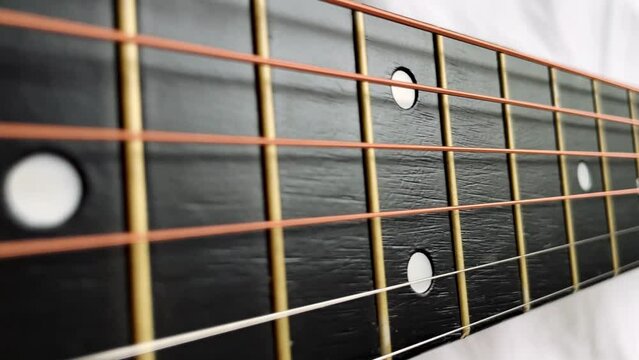 Zoom in shot of black frets fretboard acoustic guitar string. 