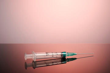 A syringe on a rose background. Photo from medical labs with copyspace. Copy space for medical ads templates. Inoculation needle on a pink surface. Photo of drug injection syringe on clean surface.
