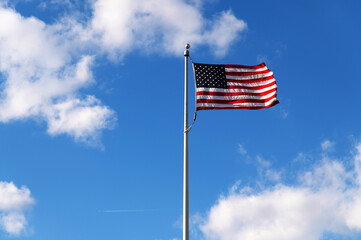 American flag waving in blue sky