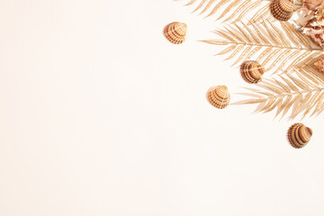 Golden palm leaf and seashells on white background. Summer, travel or vacation concept. Flat lay.