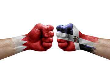 Two hands punch to each others on white background. Country flags painted fists, conflict crisis concept between bahrain and dominican republic