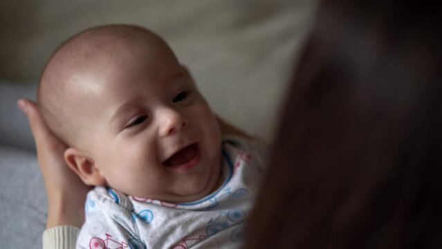 Newborn Baby With Young Mom look Into Each Other Eye. Cute Smiling Teethless Kid Face Portrait. Woman Kissing With Child Look At Camera. Infant, Mother Day, Childbirth, Beginning, Relationship Concept