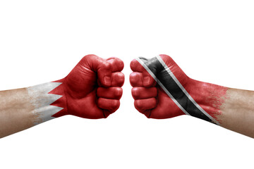 Two hands punch to each others on white background. Country flags painted fists, conflict crisis concept between bahrain and tobago
