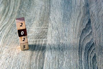 Wooden cubes with 2025 and happy new year over wooden background, banner with copy space for text,...