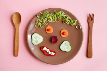 Plate with funny kids breakfast, healthy and tasty food, smiling face made of vegetables, food art