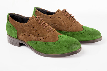 Brown and green leather shoes on white background.