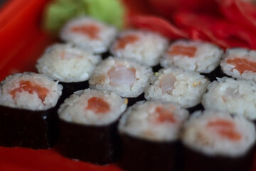 Oriental cuisine. Sushi ordered at home. Delicious dinner. Seafood on rack.